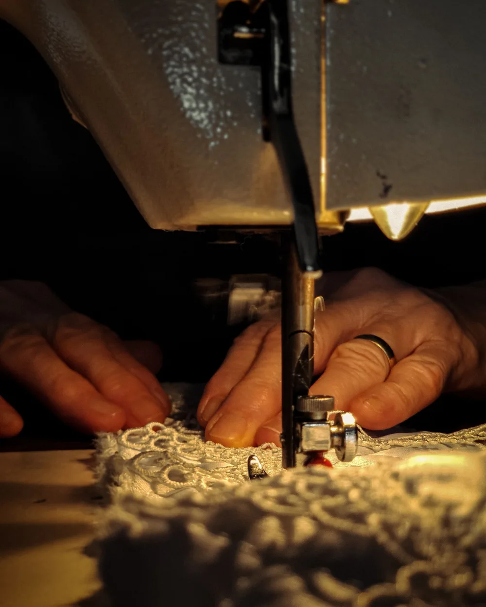 Lace being carefully sewn during dress production
